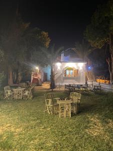 a group of tables and chairs in a yard at night at Rooma ka Guest House in Aswan