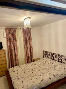 a bedroom with a bed and a chandelier at MiniAppartamento Laura - Piano terra in Chioggia