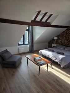 a bedroom with a bed and a coffee table at Les Nids in Dieppe