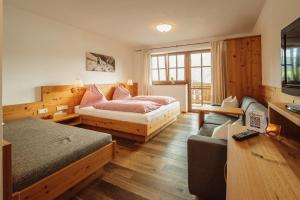 a bedroom with two beds and a couch in it at Jausenstation Pfefferbauer in Zell am See