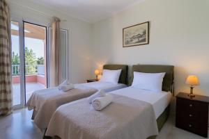 two beds in a bedroom with a balcony at Villa Olympic Azure with Private Pool in Dassia +48 photos
