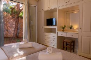 a bedroom with a bed with a mirror and a tv at Villa Olympic Azure with Private Pool in Dassia