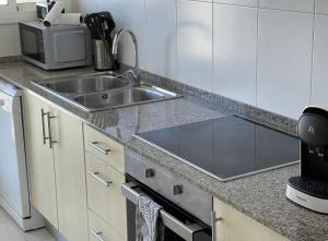 a kitchen with a sink and a microwave at Apartamento Terraza Mar in Malgrat de Mar