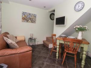 a living room with a table and a couch at Figgy Cottage in Ripon