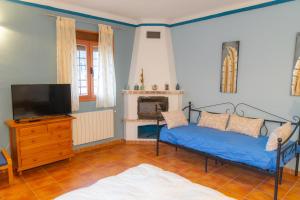 a living room with a blue couch and a tv at Casa Rural Mirabueno in Cuenca