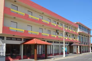 ein großes Gebäude mit roten und gelben Streifen in der Unterkunft Center Hotel in Imbé