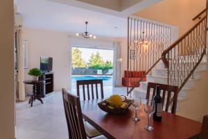 a dining room with a table with a bowl of fruit at Villa Olympic Azure with Private Pool in Dassia