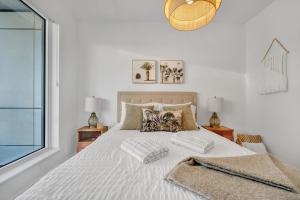 a bedroom with a white bed with two pillows at Propercare - The Wellingtons in Kitchener