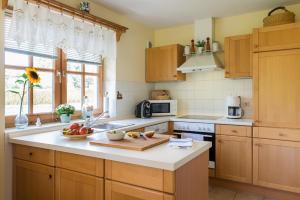 a kitchen with wooden cabinets and a white counter top at Das Sonnenhaus in Lindaunis