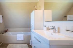 a bathroom with a sink and a bath tub at Das Sonnenhaus in Lindaunis