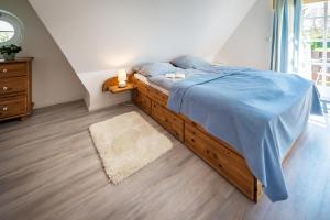 a bedroom with a bed with a blue comforter at Das Sonnenhaus in Lindaunis