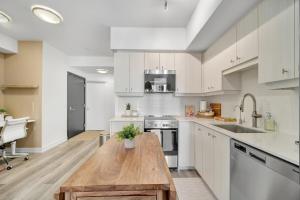 a kitchen with white cabinets and a wooden table at Propercare - The Wellingtons in Kitchener