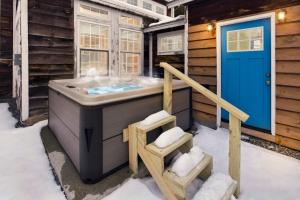 a jacuzzi tub in a wooden house with snow at Myrtle Villa 7BR Near Mount Snow with Indoor Heated Endless Style Pool Outdoor Hot Tub in Dover