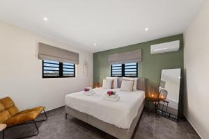 a bedroom with a large white bed and a chair at Penthouse Casa James, Mambo Beach, Jacuzzi & Sea View in Willemstad +96 photos