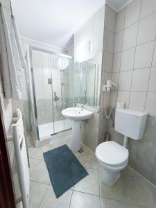 a white bathroom with a toilet and a sink at Vila Roma in Deva +46 photos