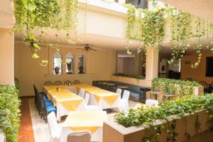 a restaurant with tables and chairs and plants at Hotel La Loma Tepic in Tepic
