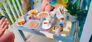 a person sitting on a balcony with a table full of food at Villa Jesmin Home - Sea View in Habaraduwa Central