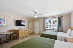 a hotel room with two beds and a television at La Terrace Oceanfront in Hollywood