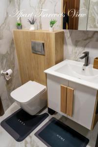 a bathroom with a white sink and a toilet at Apart Tsarevets View - Free PARKING in Veliko Tŭrnovo +26 photos
