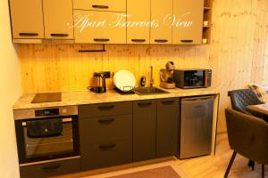 a kitchen with black cabinets and a counter top at Apart Tsarevets View - Free PARKING in Veliko Tŭrnovo