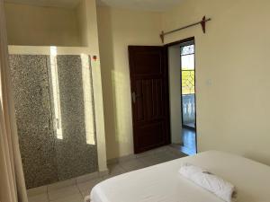 a bedroom with a bed and a sliding glass door at Figtree 1bedroom by kiv in Kilifi