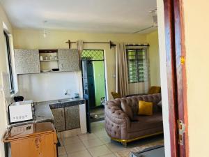 a living room with a couch and a kitchen at Figtree 1bedroom by kiv in Kilifi