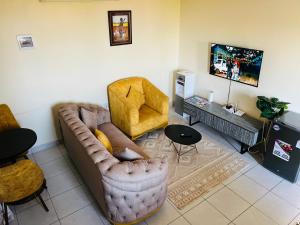 a living room with a couch and two chairs at Figtree 1bedroom by kiv in Kilifi