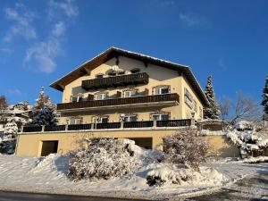 a large building with snow in front of it at Gästehaus 3-Länderblick-Panoramablick in Mönichkirchen