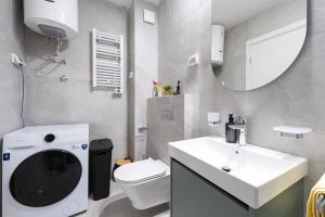 a bathroom with a sink and a toilet and a mirror at Fratello Apartment in Podgorica +17 photos
