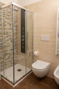 a bathroom with a toilet and a glass shower at Harmony House in Castellana Grotte