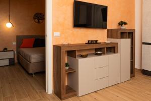 a living room with a tv on a wall at Harmony House in Castellana Grotte