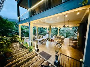 a house with a balcony with tables and chairs at Kithal Ella Station Resort in Ella