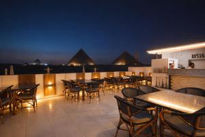 a rooftop patio with tables and chairs at night at Pyramids Holiday Escape in Cairo