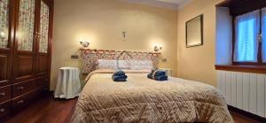 a bedroom with a bed with blue towels on it at La Casona y El Apartamento De La Foz in Lugar de Arriba