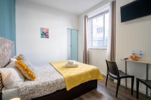 a bedroom with a bed and a chair and a window at Madeirarooms in Funchal +43 photos