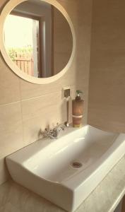 La salle de bains est pourvue d'un lavabo blanc et d'un miroir. dans l'établissement Kormoran, à Orzysz