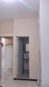 a bathroom with a door leading to a sink at Pousada Palladium in Neópolis