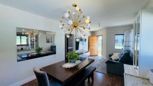a living room with a dining table and a chandelier at Jardim dos Ipês in Araranguá
