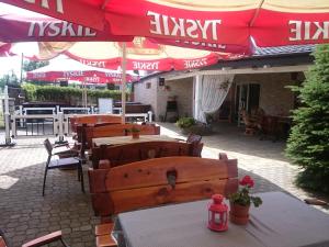 un restaurant avec des tables et des parasols sur une terrasse dans l'établissement Hotel & Restauracja Kormoran, à Orzysz