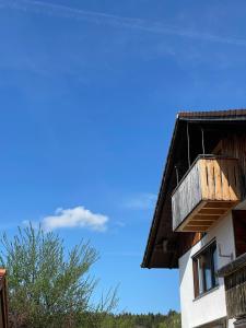 a building with a wooden balcony on top of it at Charmantes Dorf-Apartment in Dietramszell