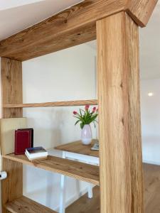 a wooden shelf in a room with a table at Charmantes Dorf-Apartment in Dietramszell