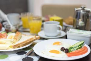 a table with two plates of eggs and bread at Epidavros Hotel in Athens +54 photos