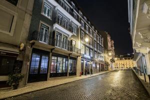 an empty street in a city at night at Olympia Lis Baixa Hotel in Lisbon