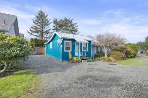 a blue tiny house on a gravel driveway at Easy Street Cottage in Rockaway Beach