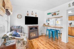 a living room with a fireplace and a tv at Easy Street Cottage in Rockaway Beach