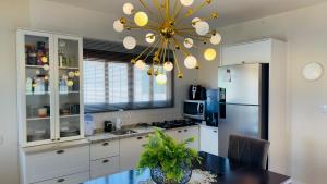 a kitchen with a chandelier and a kitchen table at Jardim dos Ipês in Araranguá +20 photos