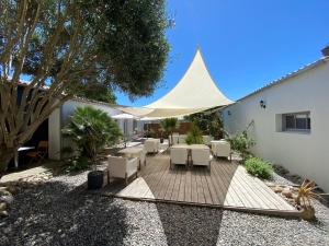 a patio with a tent and tables and chairs at Hotel Napoleon in Île dʼAix