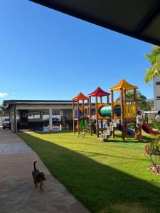 a dog walking in a park with a playground at Tulipanes 901 in Ciudad del Este