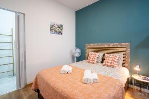 a bedroom with a bed with slippers on it at Madeirarooms in Funchal
