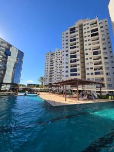 a swimming pool in front of two tall buildings at Tulipanes 901 in Ciudad del Este